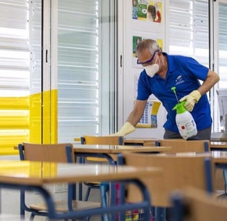 a man in a blue shirt and a white shirt cleaning a desk
