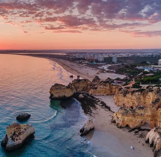 Golden cliffs and sandy beach of Alvor, Portugal, at sunset