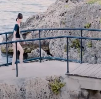 a woman walking across a pontoon.