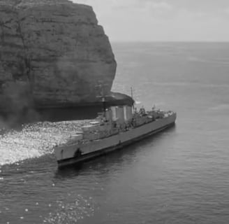 A World War II battle ship moored in a bay.