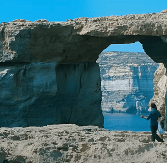 A couple dance in front of the Azure Window.