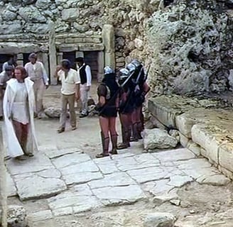 A group of people standing around a stone temple.