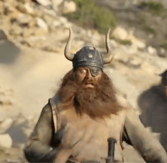 A man with a large red beard in a viking helmet.