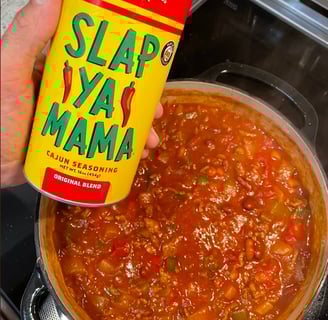 a person holding a can of slap ya ya mama chili sauce