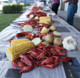 a table with a bunch of crawfish and potatoes