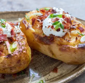 Golden-brown potato skins filled with creamy whipped potatoes, topped with melted cheese and crispy 