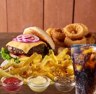 a burger with fries onion rings and a soft drink