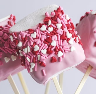 Large marshmallows dipped in pink chocolate and covered with heart-shaped sprinkles