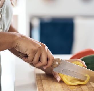 Woman cutting a bellpepper on a chopping board