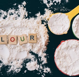 flour and measuring cups on a kitchen counter