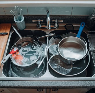 a kitchen sink with pots and pans of cooking utensils