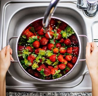 Someone washing strawberries in the sink