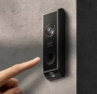 Eufy doorbell on the wall and somone pushing the button