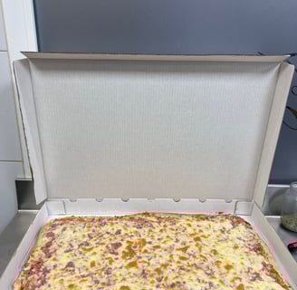 a pizza box with cheese and sausages