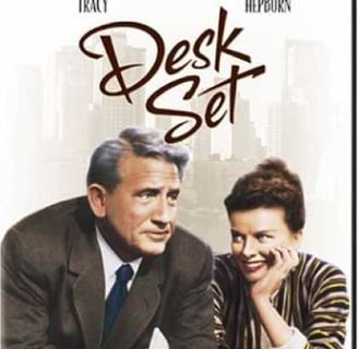 a man and woman sitting at a desk with desks