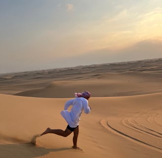 a man in a white shirt is running through the desert