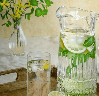 jarra de água com limão e hortelã em mesa minimalista