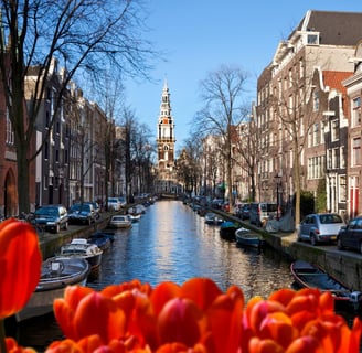 amsterdam - a canal with boats and a church steeple