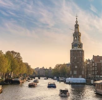amsterdam - a river with boats and buildings in the background