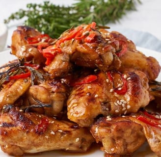 a plate of chicken wings with a side of chili