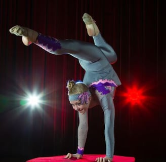 a woman doing a handstand on a stage