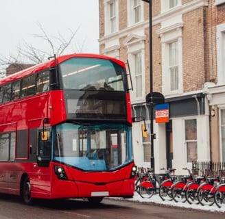 a red double decker bus parked on the side of a street
