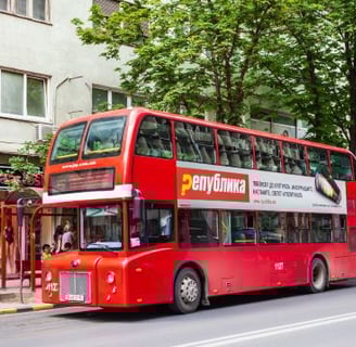 a red double decker bus parked on the side of a street