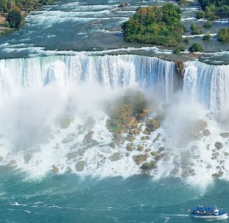 a boat in the water near a waterfall