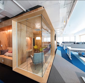 a glass walled office space with a couch and a chair in Dubai