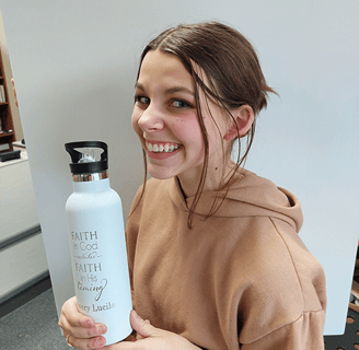 a woman holding a bottle of water in her hand