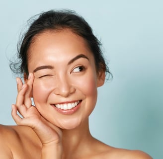 Smiling woman winking and showing radiant skin.