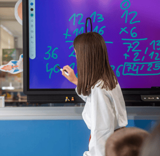 Teacher using the TICTIC interactive whiteboard app to deliver visual lessons with touch-enabled tools in a smart classroom.