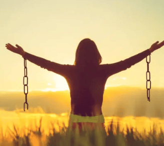 a woman standing in a field with her arms outstretched out and arms outstretched out