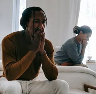 a man and woman sitting on a couch in a living room