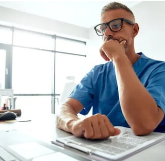 a man sitting at a desk with a keyboard and a computer