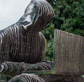 a statue of a man sitting on a bench