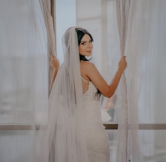 Novia con vestido blanco de espaldas abriendo cortina - Mejor fotógrafo de bodas en Guadalajara, Mx