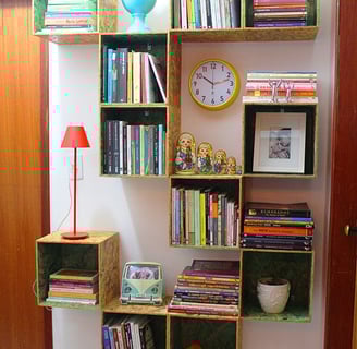 a bookshelf with books, decorations and a lamp 