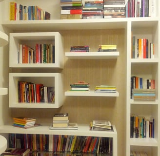 a room with a book shelf and a lamp