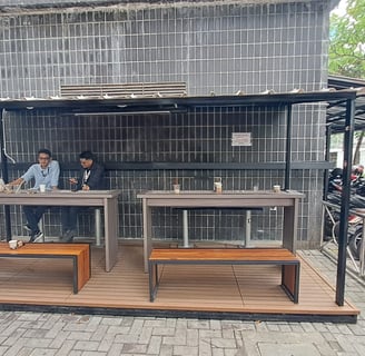 a man and woman sitting at a table with a dog in the background