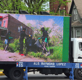 Projector Screen showing 3 people cleaning up neighborhood