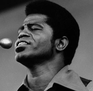 Black and White Portrait of James Brown on Stage singing into a microphone