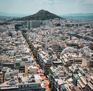 a cityscape of Athens with Lykavittos hill in the background