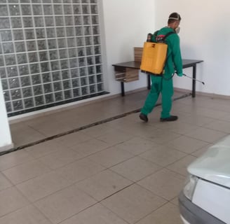a man in green scrubsuit carrying a yellow suitcase