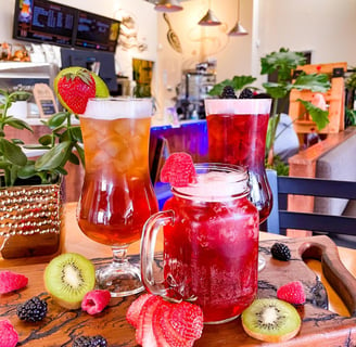 a table with a variety of ice teas and flavored lemonade