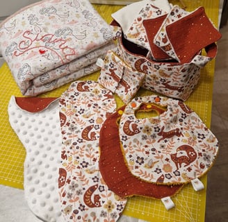a table with a bunch of cloths and a sewing machine