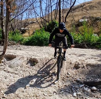 Mountain biker riding through deep sand with steady speed and balance.