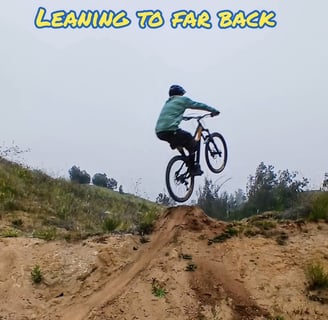 Mountain biker leaning too far back off the takeoff, front wheel rising too high