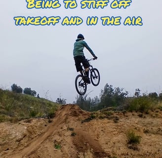 "Mountain biker stiff in the air with extended arms and legs