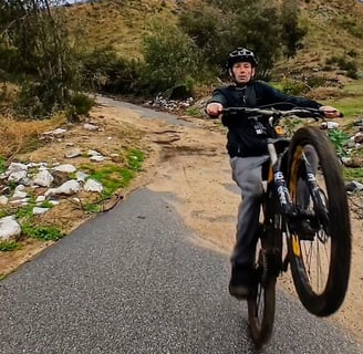 Mountain bike rider practicing manual and wheelie techniques for skill building